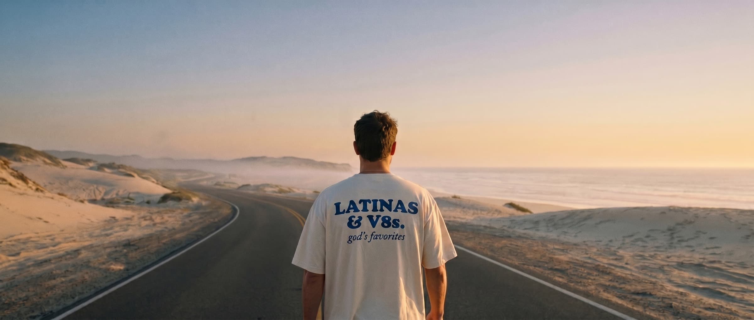 Walking an empty coastal road at golden hour in the Latinas & V8s tee